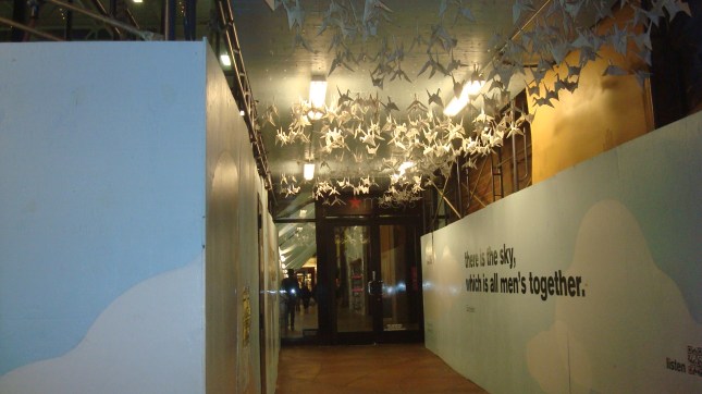 Origami cranes suspended from scaffolding.