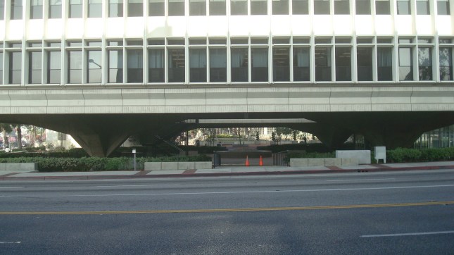 The building is lifted above street level by pylons of steel and concrete.